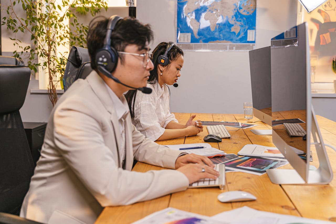 why-choose-us Call center agents working at computers with headsets in a modern office setting.